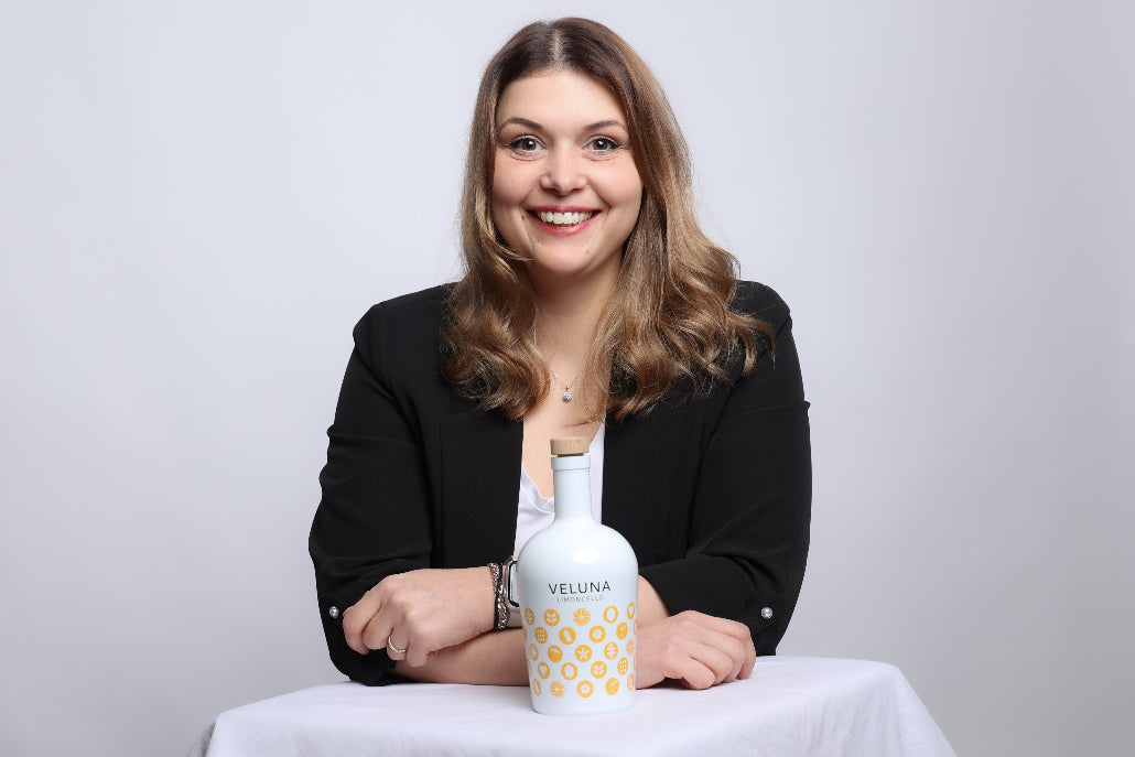 Laura-Marie Krause Gründerin von VELUNA Limoncello  zusehen mit Flasche von VELUNA Limoncello